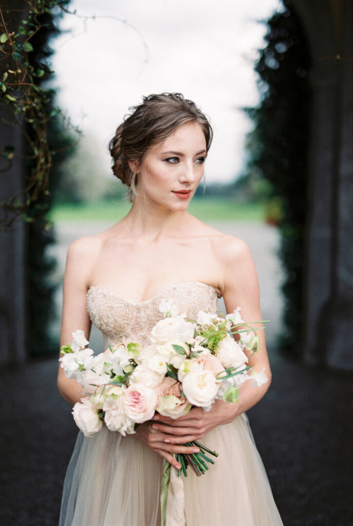Bride with a bouquet on the background of an arch in an old villa. High quality photo